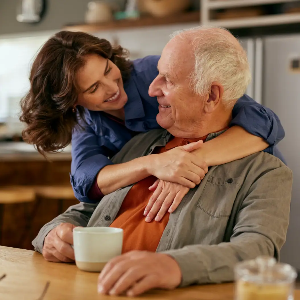 a man and woman smiling and holding a cup of coffee
