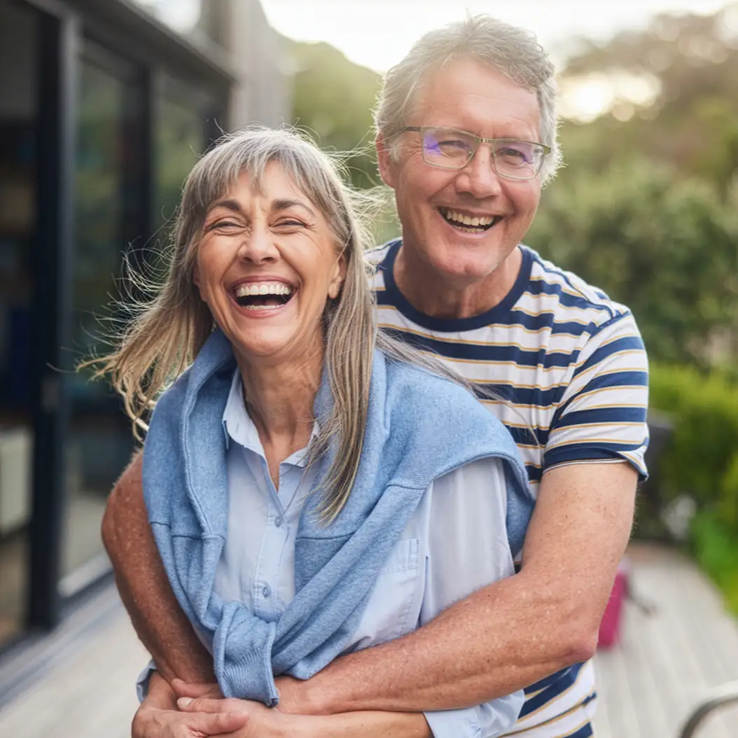 a man and woman smiling and holding a cup of coffee